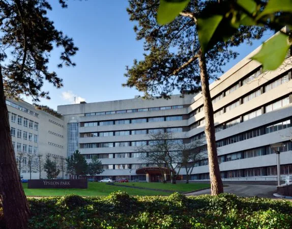 Kantoorgebouw Ypsilon Park aan de Floris Grijpstraat, omringd door bomen en groen.